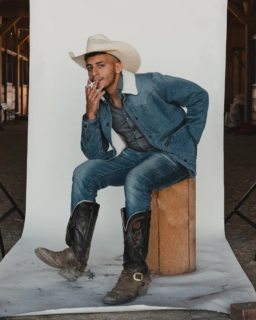 Aly Soltan, Area Director, seated in a cowboy hat, denim jacket and boots